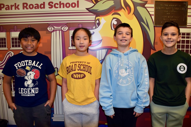 Students smiling against artwork of school.