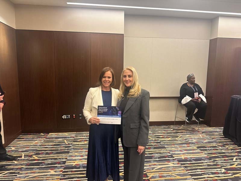 Award winner smiling with board trustee.