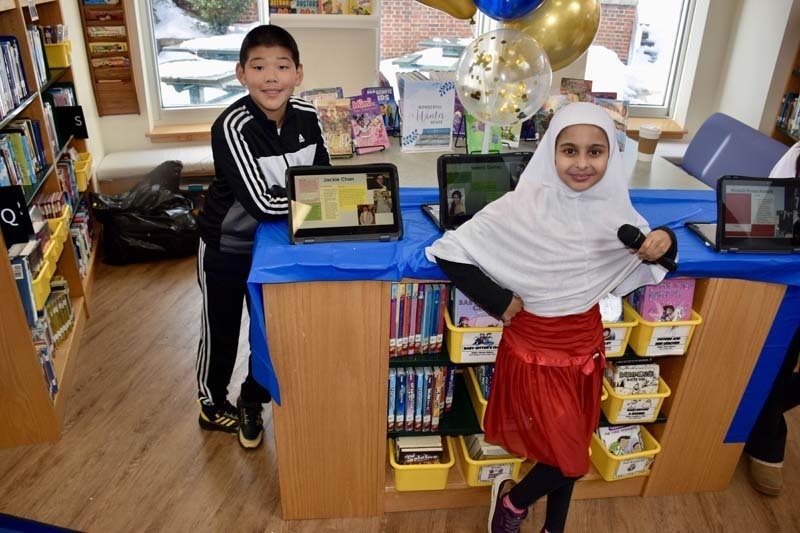 Students smiling with tablets.
