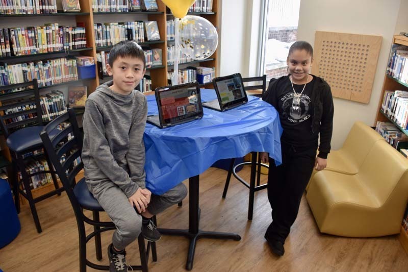 Students smiling with tablets.