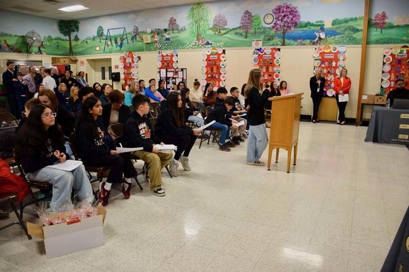 Students standing proudly in front of science fair projects.