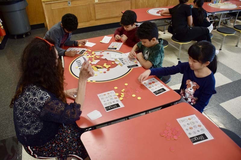 Teacher sitting at table with parent and student.
