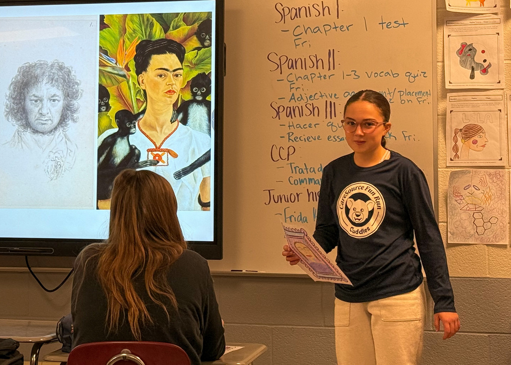 Student presenting the self portrait they created to the class. 