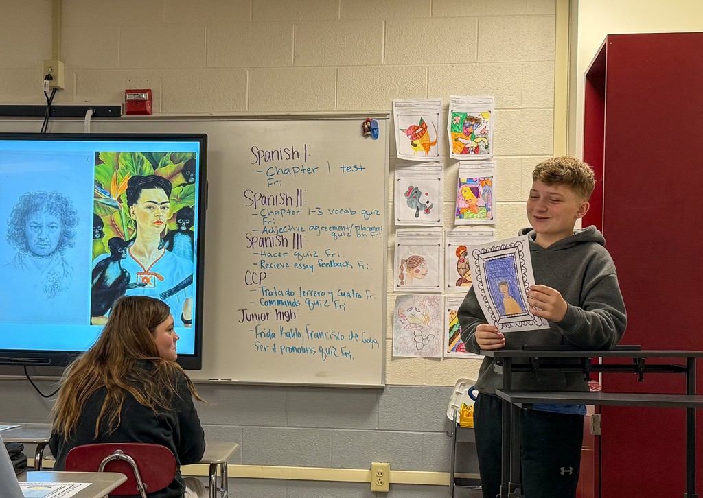 Student presenting the self portrait they created to the class. 