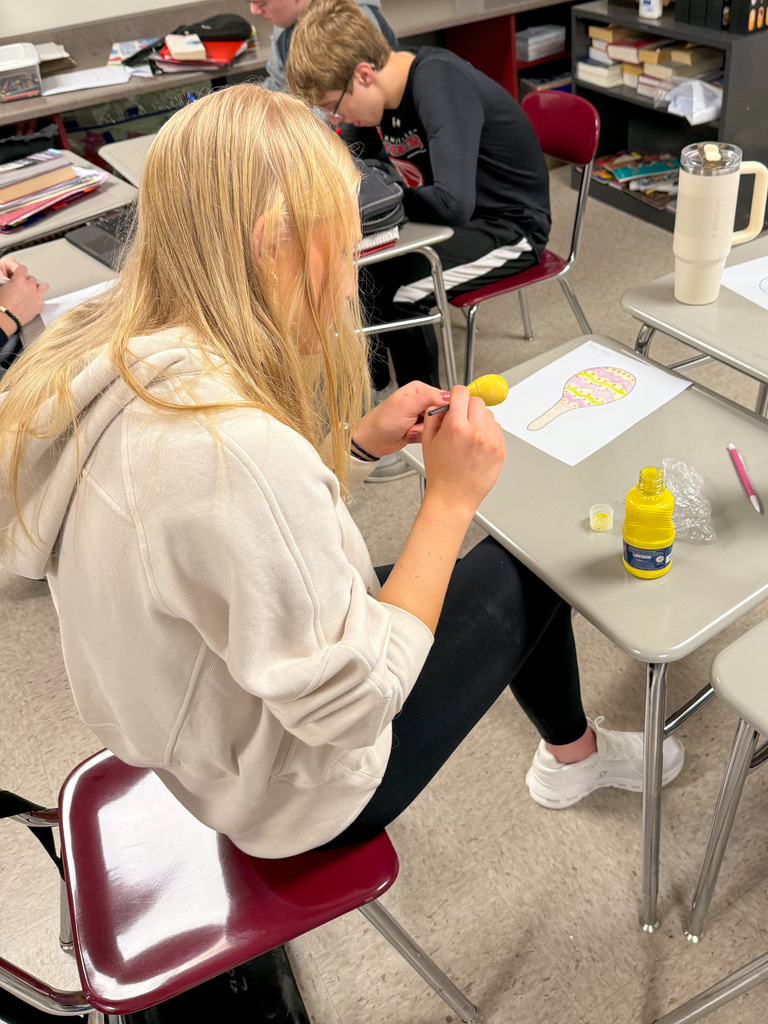Student painting maraca.