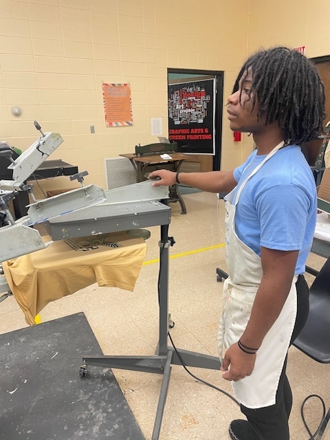 A student curing the Ink on a t-shirt.