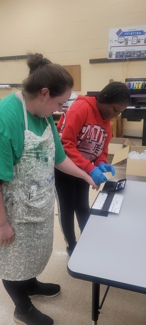 A female students fingerprinting a female adult.