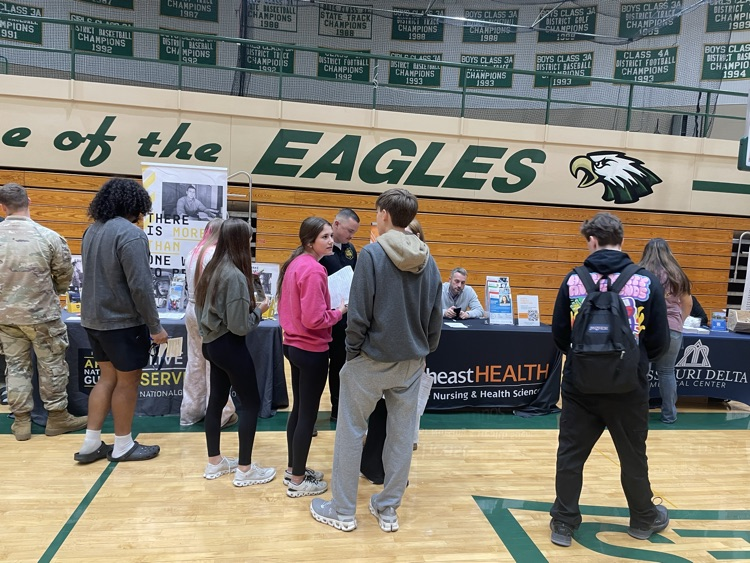 another group of students visiting a booth at a career fair