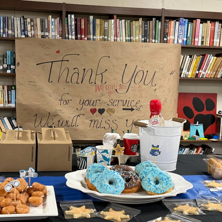A sign with messages from students hats behind the breakfast spread
