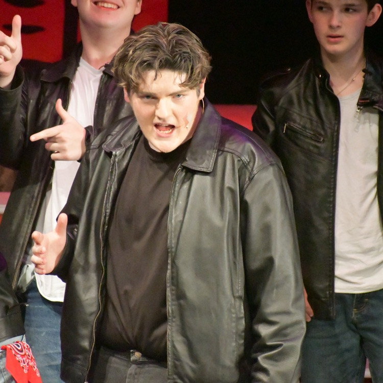 An actor on stage during Grease