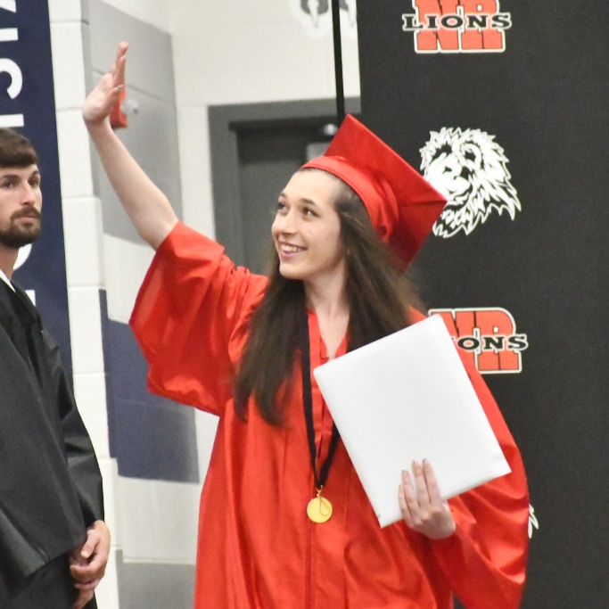 graduate waving to the crowd