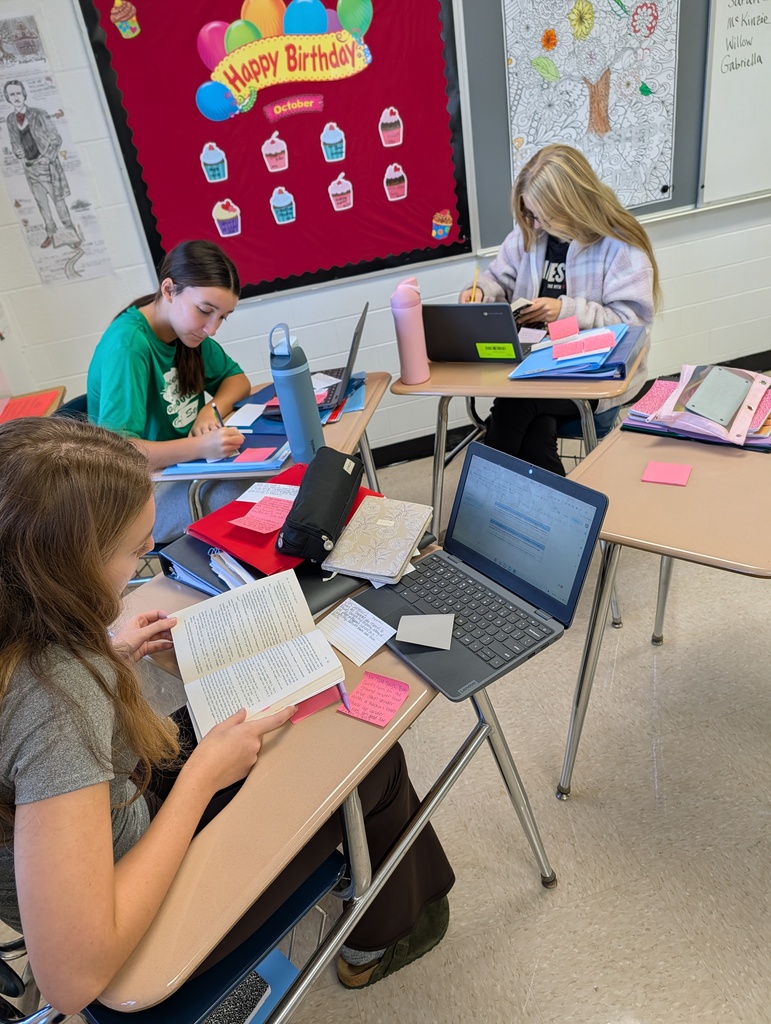 A group of students in an Advanced English 2 classroom working together on character traits and textual evidence.