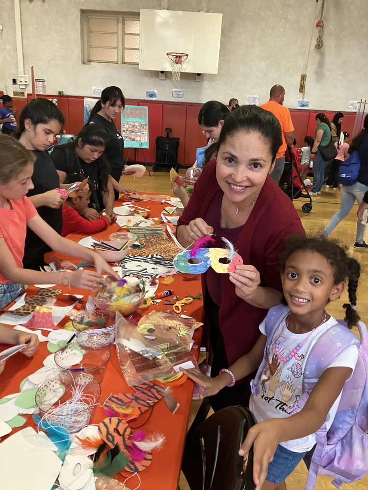 A teacher and student smiling at the science fair and making masks