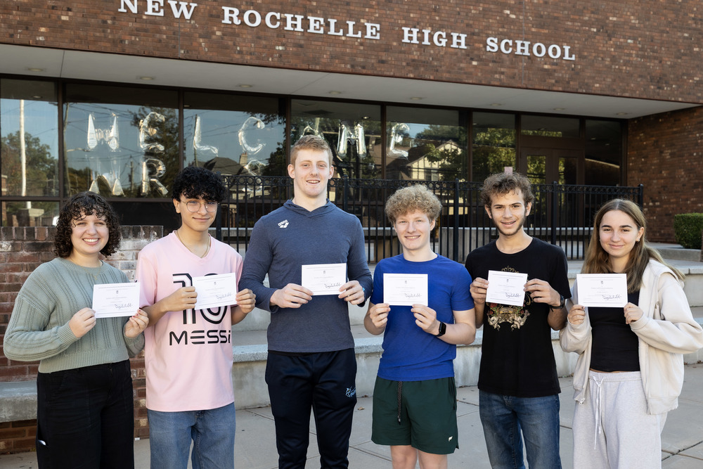Six students holding National Merit certificates