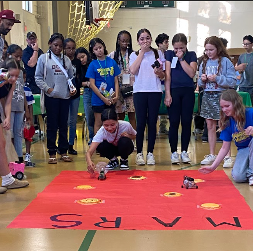 A group of happy students learning wity robots