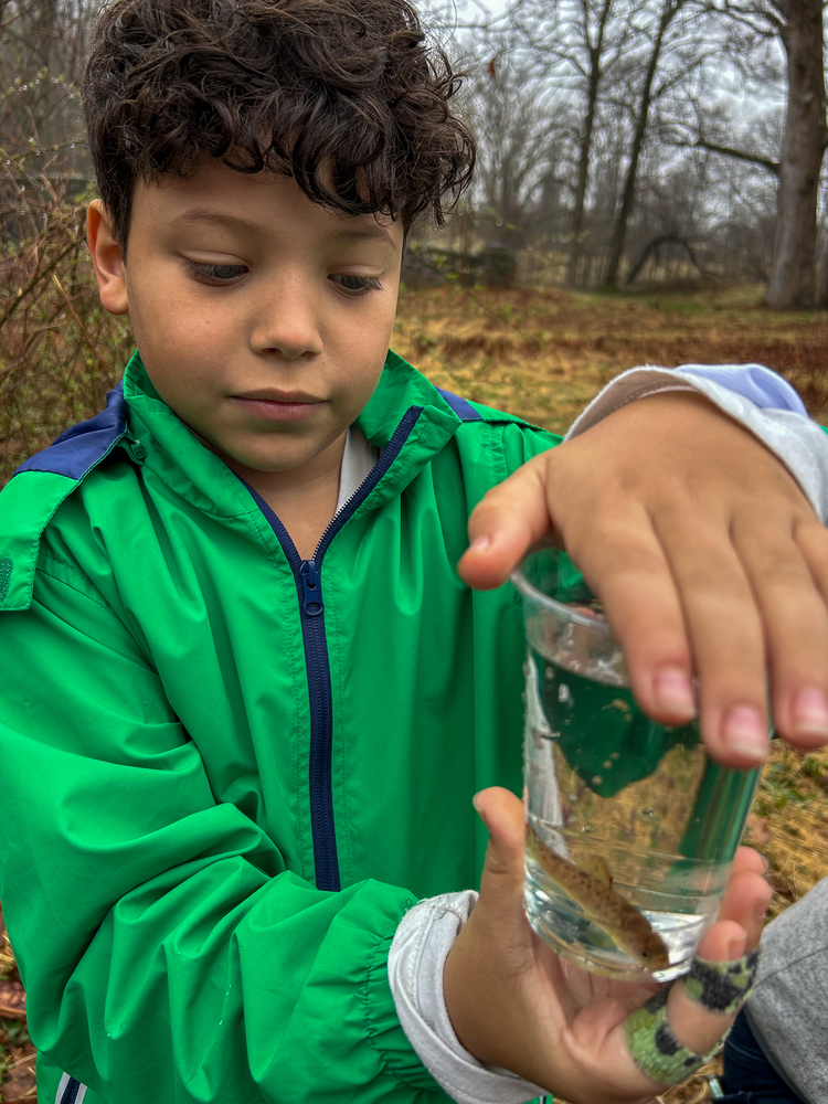 Student with trout in cup