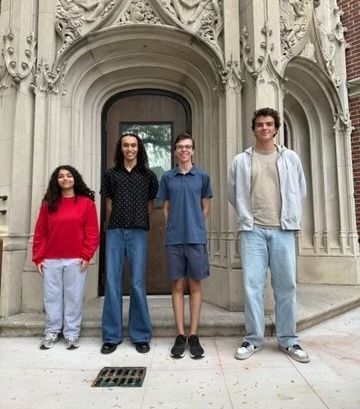 Four students standing outside school