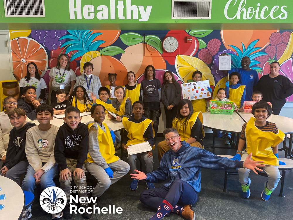 students in yellow vests and blue gloves with principal hilderbrand