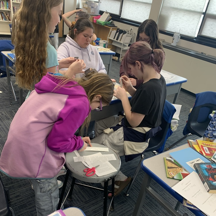 Fifth grade making bookmarks out of old books for reading month!