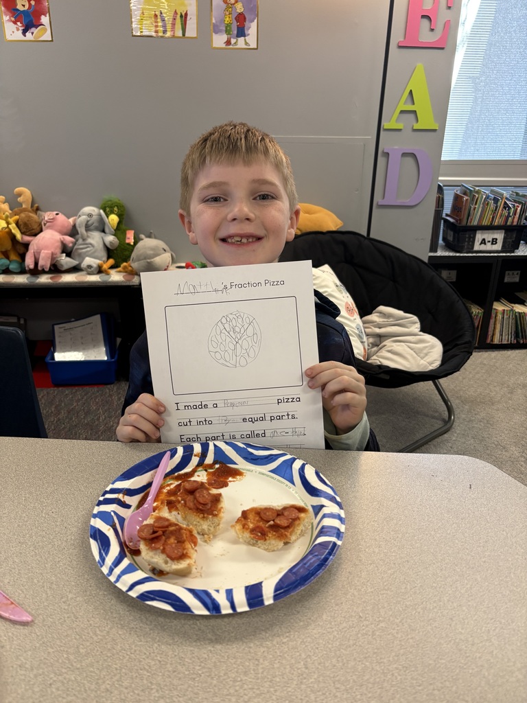 A student with their completed pizza bagel broken up  into a specific fraction as detailed on their worksheet.