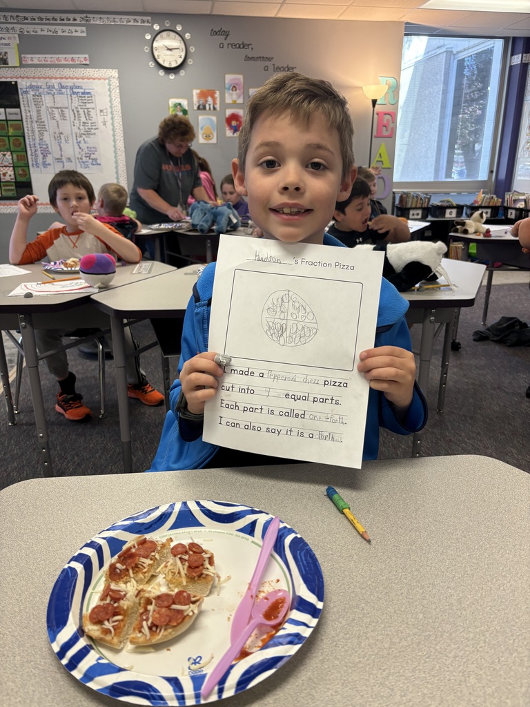A student with their completed pizza bagel broken up  into a specific fraction as detailed on their worksheet.