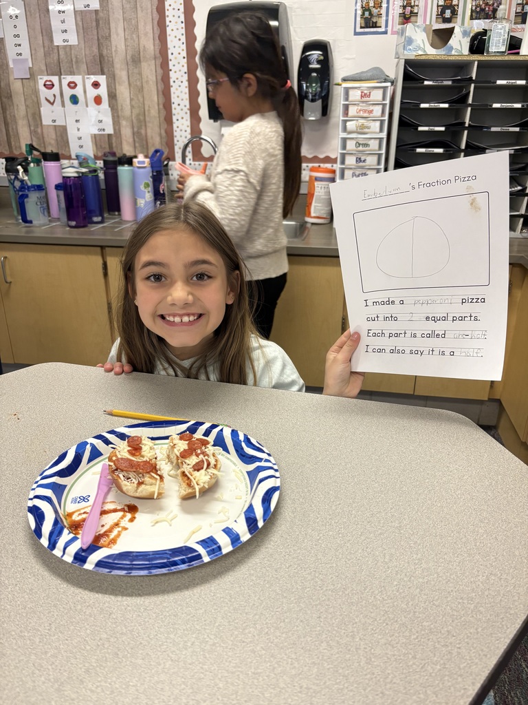 A student with their completed pizza bagel broken up  into a specific fraction as detailed on their worksheet.
