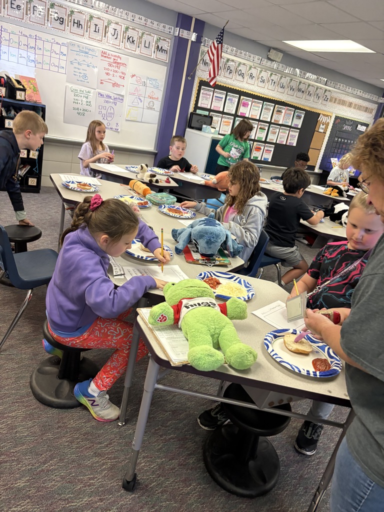 A group of students working on making their pizzas on a bagel.