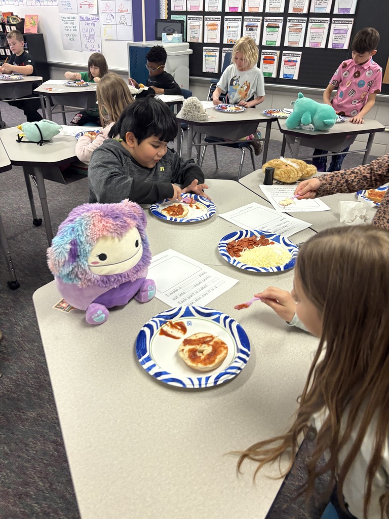 A group of students working on making their pizzas on a bagel.