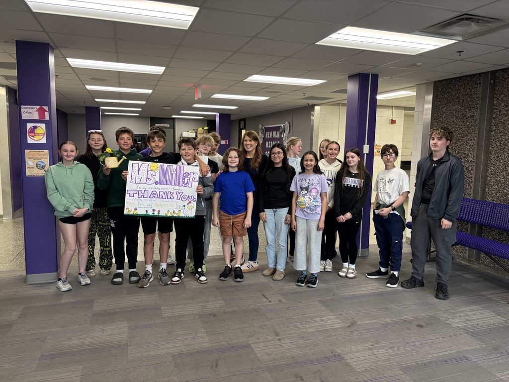 A group photo with a class of students and Principal Miller, with a sign thanking Ms. Miller.