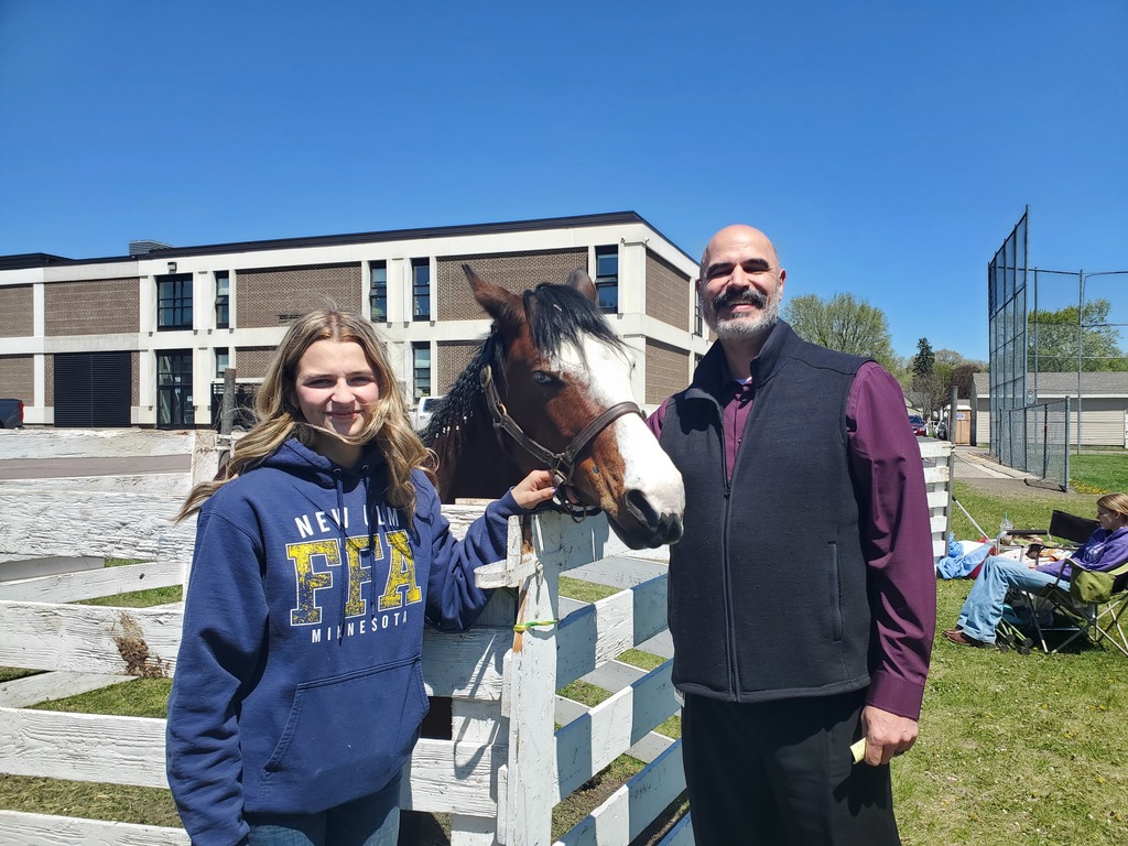 An FFA student, a. horse in a pen, and Sean Koster the superintendent pose for a photo.