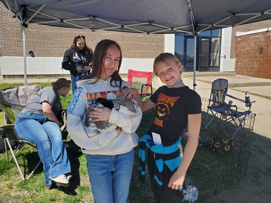 3 FFA students and a younger student with domestic rabbits.