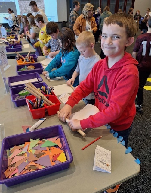 Multiple students working on stuff in a hands-on exhibit.
