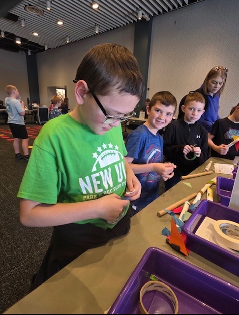 Multiple students working on stuff in a hands-on exhibit.