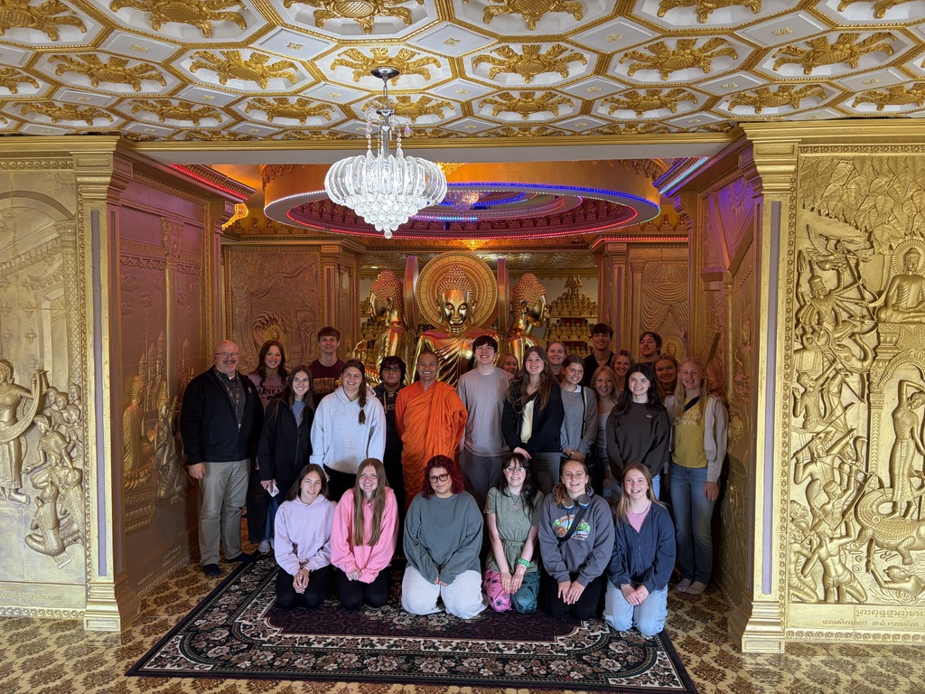 Class and their teacher, along with the Buddhist member, posing for a photo inside the temple.
