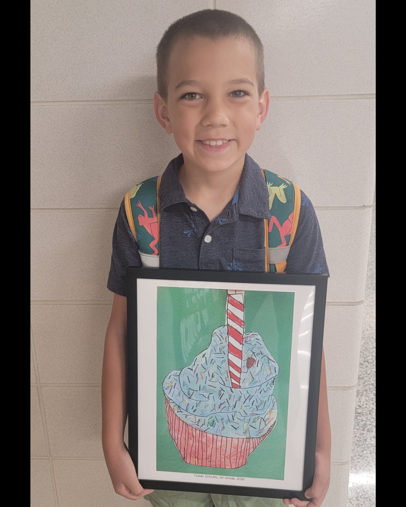 1st grader Nolan. S holding his illustration of a cupcake with sprinkles.