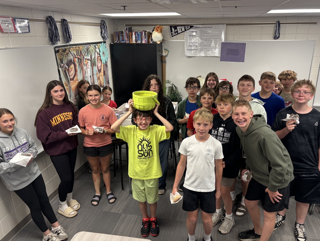 Group of students with donuts, a student in the center holding a basket above his head.