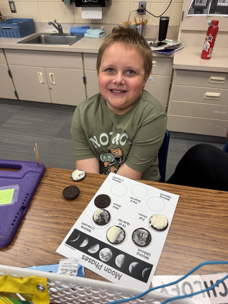 A student with a partially finished moon phase cycle made out of oreos.