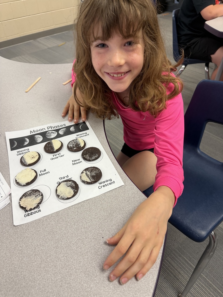 A student with a completed moon phase cycle made out of oreos.