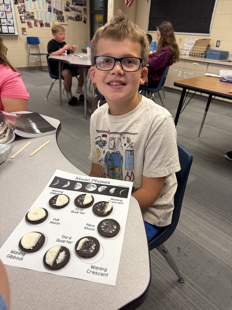 A student with a completed moon phase cycle made out of oreos.