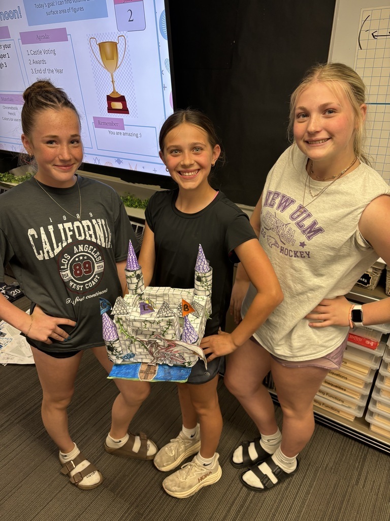 3 students holding the castle they made that won them the competition.
