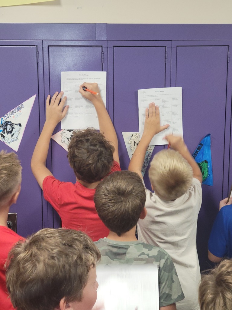 Kids using lockers to right on their bingo cards.