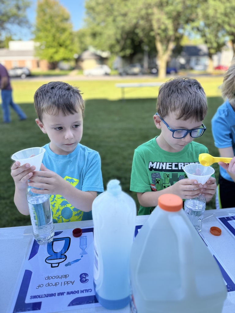 Two young boys at a table with dish soap.