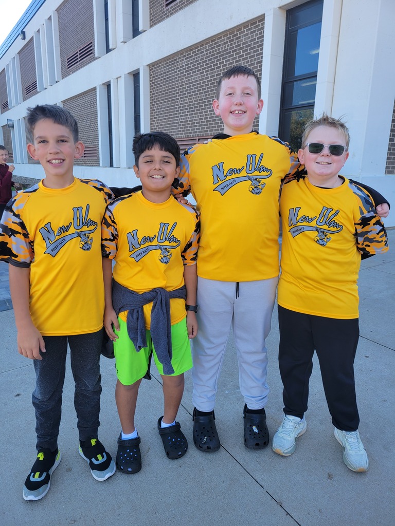 Four boys in matching yellow t-shirts posing for a photo.