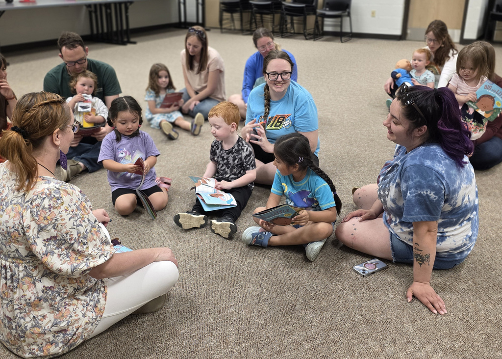 moms sitting with their child reading books