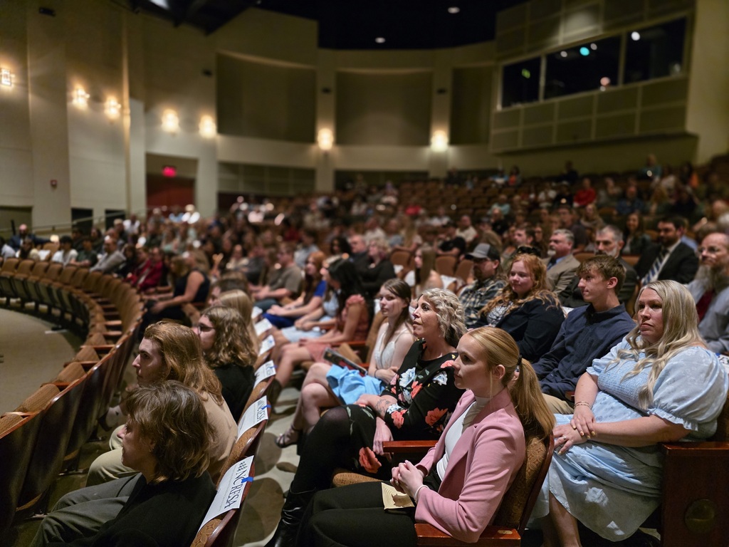 A large audience sits in a theater-style auditorium watching the Student Showcase ceremony.