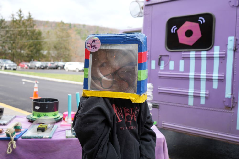 one student smiling as they interact with the physics bus
