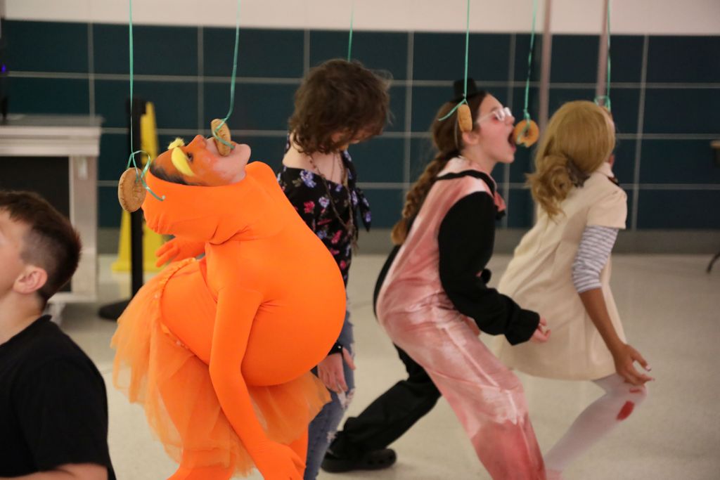 students trying to eat donuts off a string