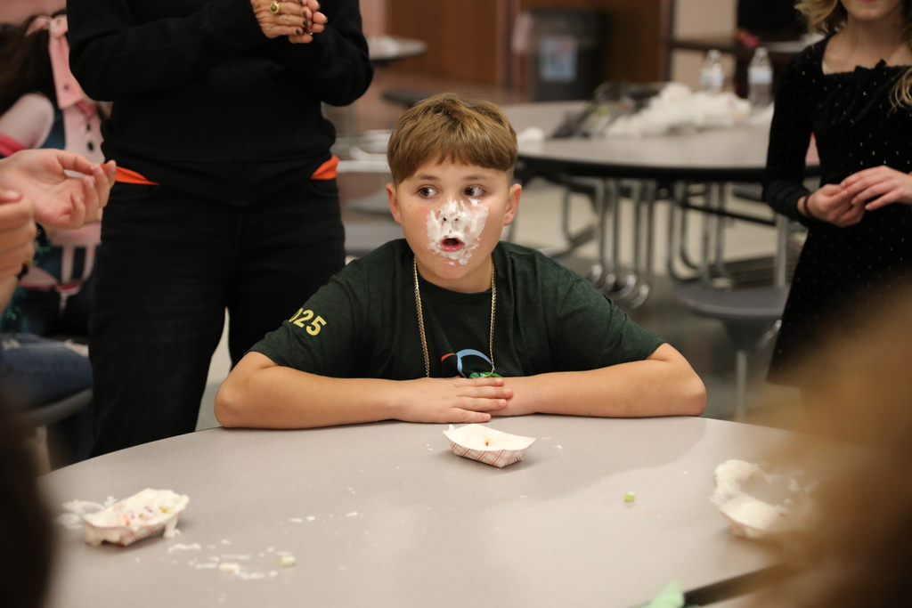 A student with face covered in whipcream
