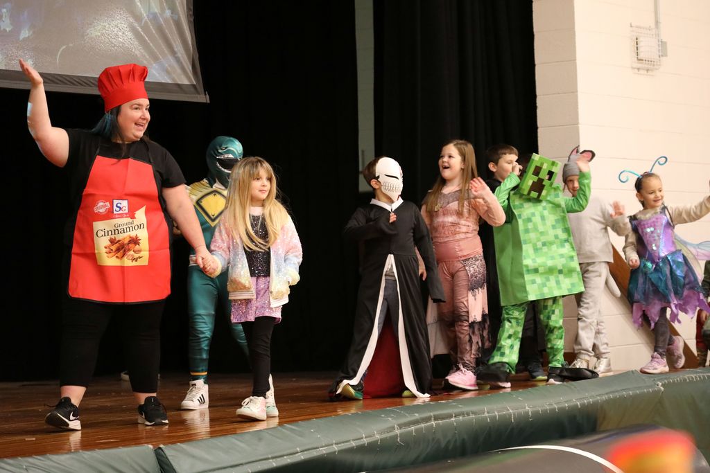A class walking across stage in their costumes