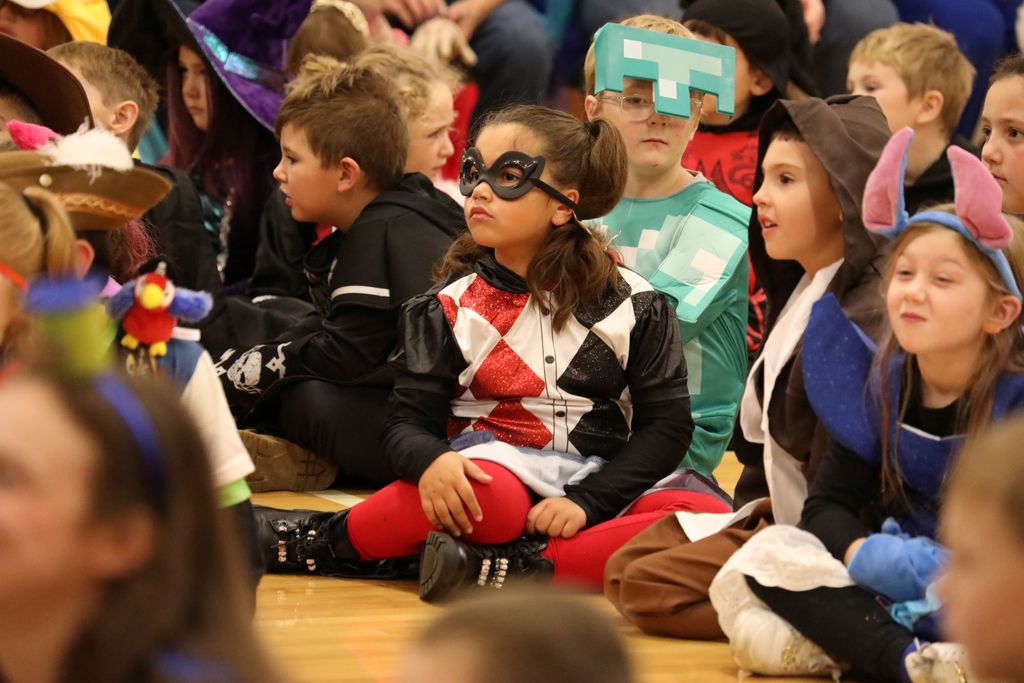 a group of costumed students sitting on the floor